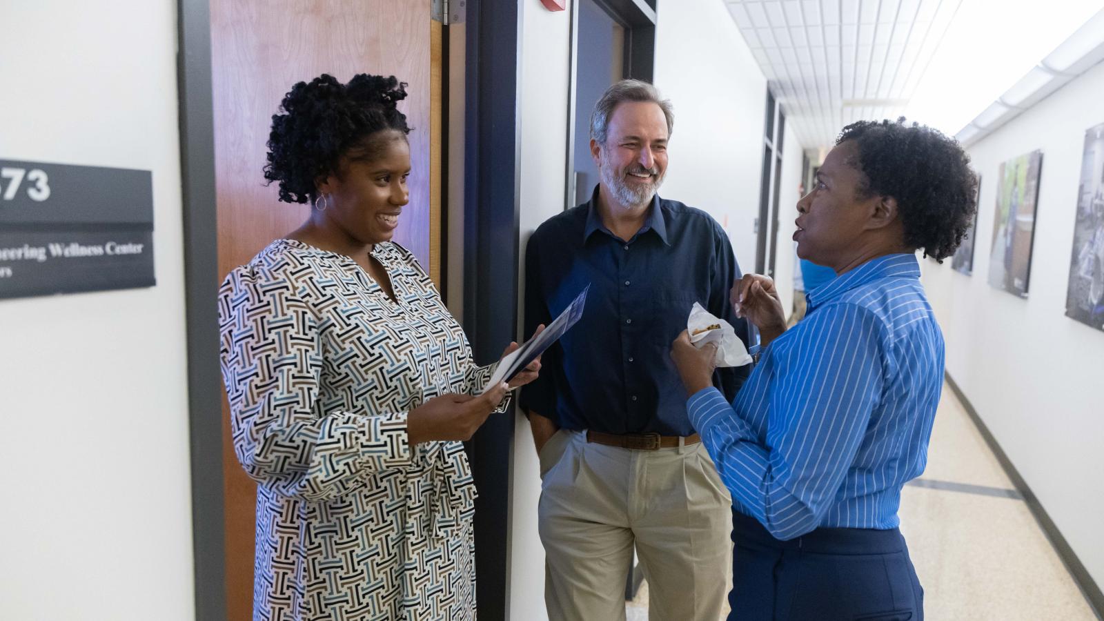 April Porter, Mike Johnson and Johné Parker talking outside of office